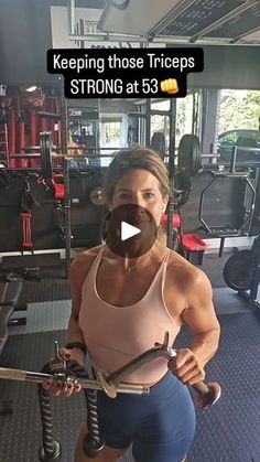 a woman holding a barbell in a gym