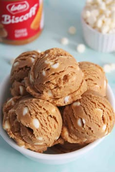 a white bowl filled with ice cream and marshmallows next to a can of biscoff