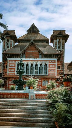 an ornate building with steps leading up to it and potted plants on the side