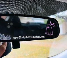 a car mirror with a pink ghost sticker on it