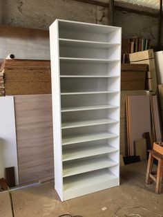 an empty book shelf in a room with many shelves