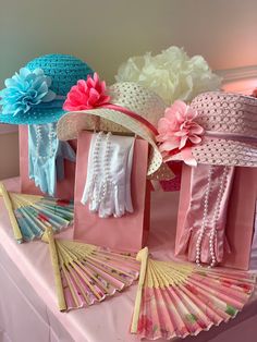 several hats and fan on display in a room with pink, blue, and white decorations