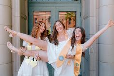 three women in white dresses are posing for the camera with their arms spread wide open