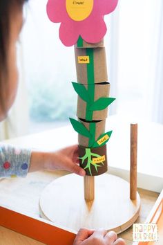 a child is making a flower made out of toilet paper and cardboard rolls on a table