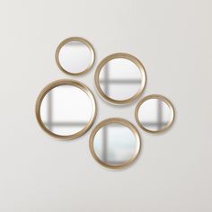 four circular mirrors are arranged on the wall