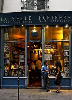 two people standing in front of a book store