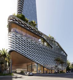 an architecturally designed building on the corner of a street in front of palm trees