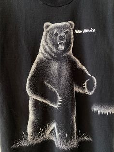 a black t - shirt with an image of a bear on it