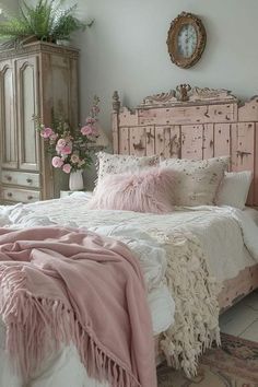 a white bed with pink pillows and blankets