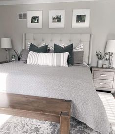 a large bed sitting in a bedroom next to two lamps and pictures on the wall