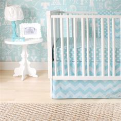 a baby's room with blue and white wallpaper, a crib and rug