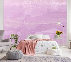 a bedroom with a bed, chair and rug in front of a large purple wall