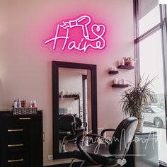 a hair salon with pink neon sign above the chair