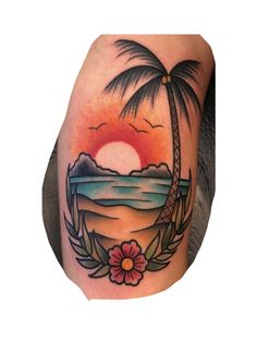 a man's arm with a palm tree and flowers on it