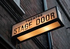 the theatre stage door sign is lit up