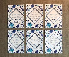 four blue and white tile coasters with flowers on them, one has the words