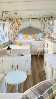 the interior of a camper with white furniture and yellow pillows on it's bed