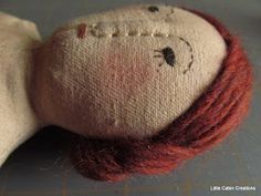 a close up of a stuffed animal with red hair on it's head and eyes