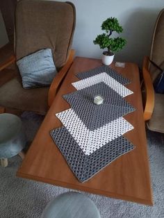 a coffee table with two chairs and a potted plant