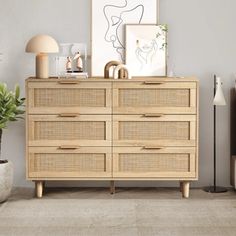 a wooden dresser sitting next to a plant in a living room