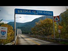 bridge of the gods sign on highway with trees and mountains in backgroung