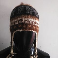 a mannequin head wearing a knitted hat with braids on it's sides