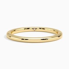 a yellow gold wedding band with a single diamond in the center, on a white background