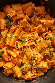 a pan filled with pasta covered in sauce and parsley