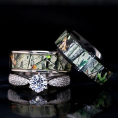 two wedding rings with mossy camo on them and a diamond in the middle