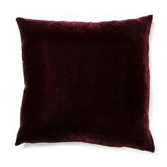 a dark red velvet pillow on a white background