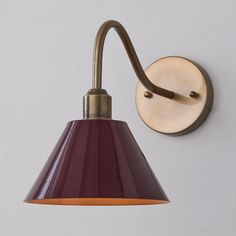 a wall light with a red shade on it's side and a white background