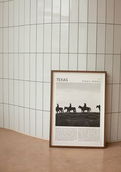 a framed photograph sitting on top of a counter next to a wall mounted tile pattern