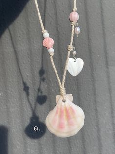 a necklace with seashells hanging from it's sides