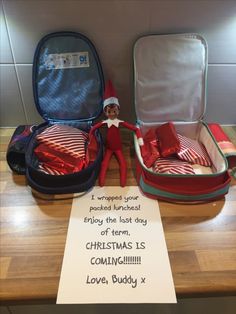 an elf is sitting next to two open suitcases and a note that says, christmas is coming love buddy