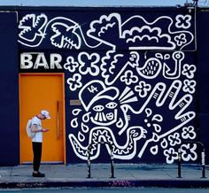 a man standing in front of a building with graffiti on it