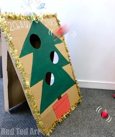 a cardboard christmas tree cut out on the floor