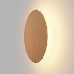 a light that is on the side of a wall with a circular mirror in it