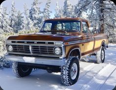 an old truck is parked on the side of the road in front of snow covered trees