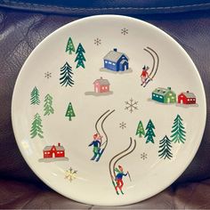 a white plate with skiers and houses painted on it