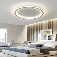 a bed room with a neatly made bed and a round light on the wall above it