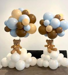 two teddy bears sitting on top of balloons in the shape of flowers and clouds,