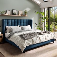 a bedroom with a blue bed and windows