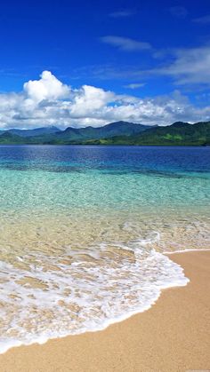 the ocean is clear and blue with white clouds