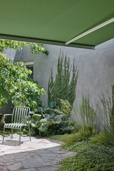 a green chair sitting on top of a stone patio