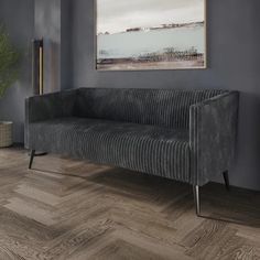 a living room with grey walls and wood flooring that looks like chevron herringbones