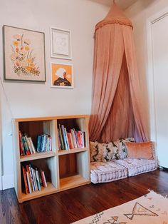 a living room with bookshelves, couch and pictures on the wall above it