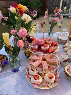 a table topped with plates filled with cakes and cupcakes on top of it