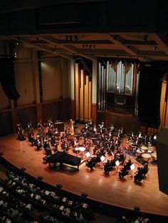 an orchestra on stage with instruments and conductor