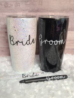 two bride and groom glitter tumblers next to a pen on a white fur rug