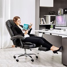 a woman sitting in an office chair reading a book